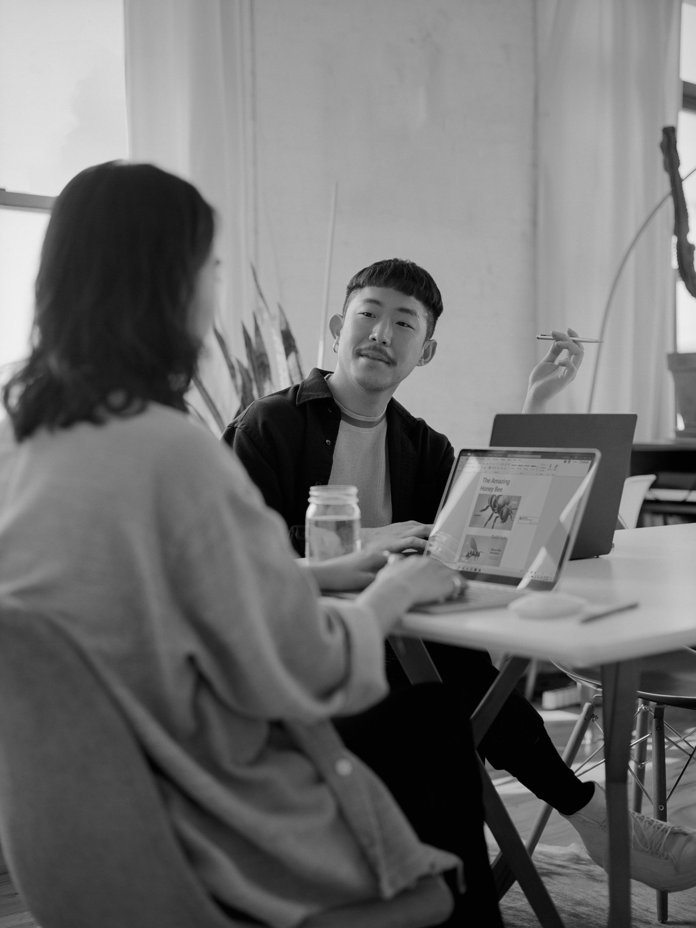 Two creatives collaborating over a laptop.